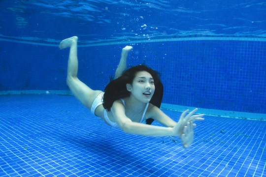 漂亮的青年女人在水下游泳