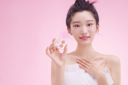 漂亮的青年女人拿着眼影盘