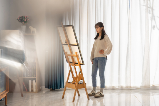 房间里一位亚洲华裔青年女人在绘画