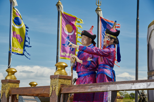 草原上蒙古包前穿蒙古族传统服饰的年轻夫妻