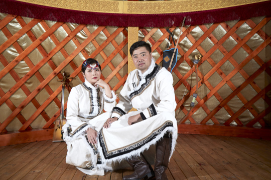 草原上蒙古包里穿蒙古族传统服饰的年轻夫妻