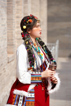 身穿藏族服饰在古城拍照的少女