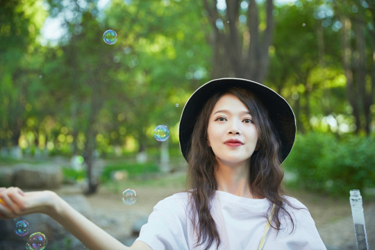 户外公园里玩吹泡泡的可爱亚洲少女