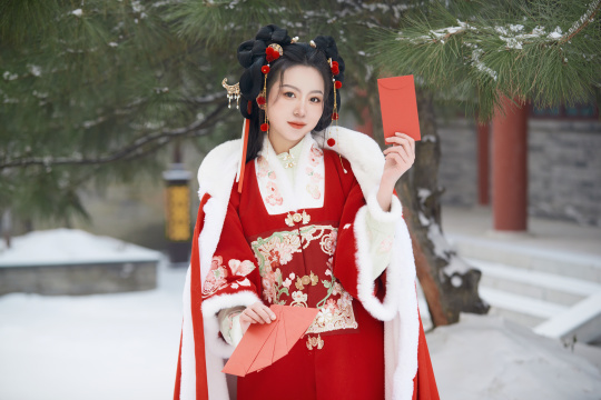 雪天户外身穿中式红色汉服的亚洲少女