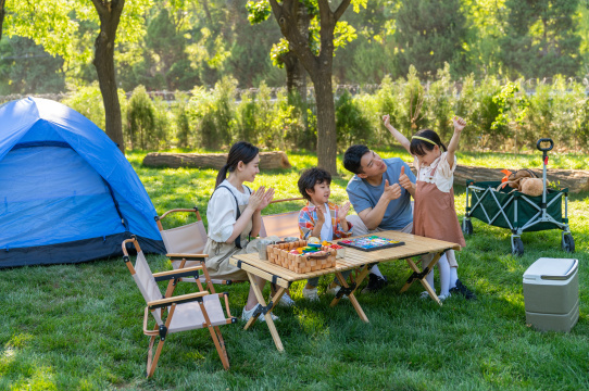 一家四口在露营地玩游戏开心欢呼庆祝