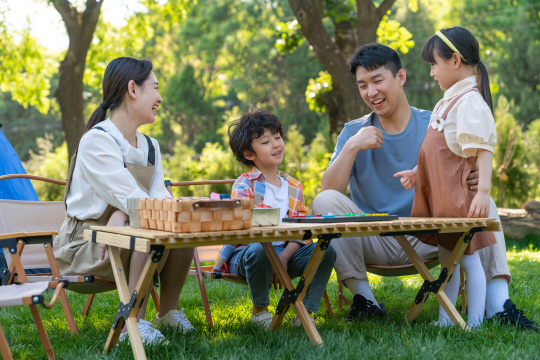 一家四口在露营地玩游戏开心欢呼庆祝