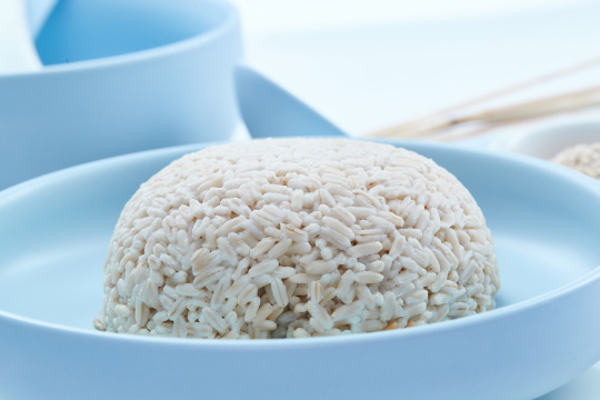 白色纸背景上的青釉瓷餐具及木质餐具装的燕麦米