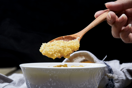 手持木勺?起的美味香浓小米粥