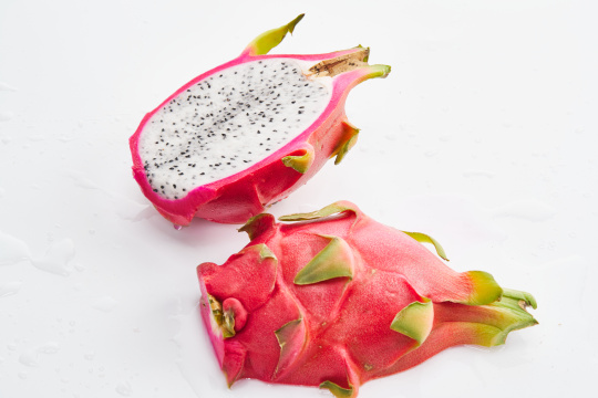 白色背景上摆放切开的新鲜火龙果