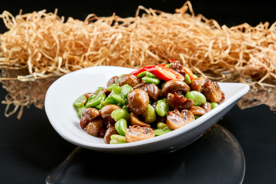 白色瓷盘装的塞外口蘑小炒青蚕豆