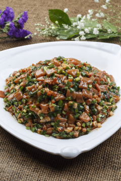 三角形白瓷盘装的海鲜韭菜炒海肠