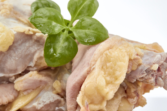 摆放在白色背景上分切好的生鲜鸡腿