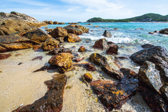 中国深圳东涌海岸蓝天白云下的礁石与大海
