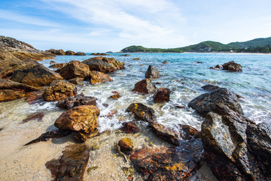 中国深圳东涌海岸蓝天白云下的礁石与大海