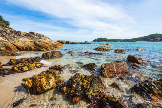 中国深圳东涌海岸蓝天白云下的礁石与大海