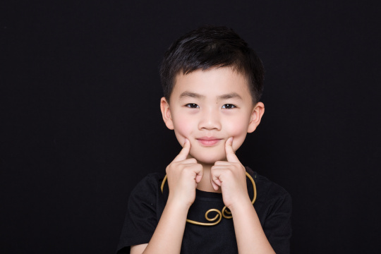 黑色背景下可爱的中国小男孩肖像