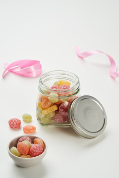 水果形状的糖果装满了玻璃瓶和盘子。 