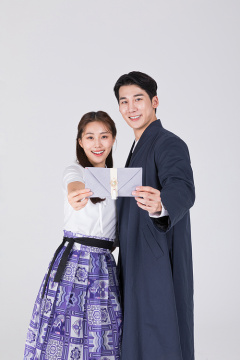 秋夕购物_一对夫妇拿着婚礼包的照片图像 