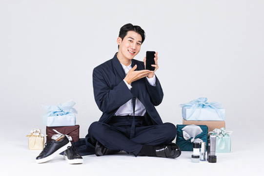 秋夕购物_一位坐着的男子与传统盒子和男士商品的照片图像 