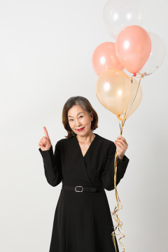 老年妇女_一位中年妇女手持气球的照片 