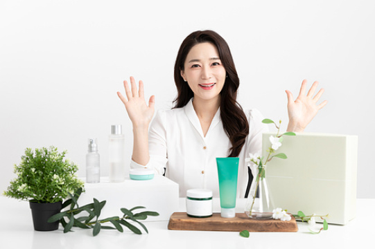 一位女士在购物直播节目中介绍化妆品的画面 