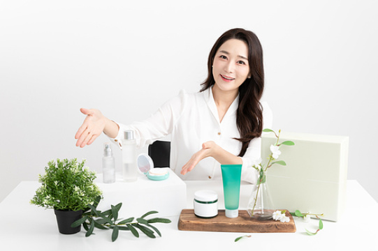 一位女士在购物直播节目中介绍化妆品的画面 