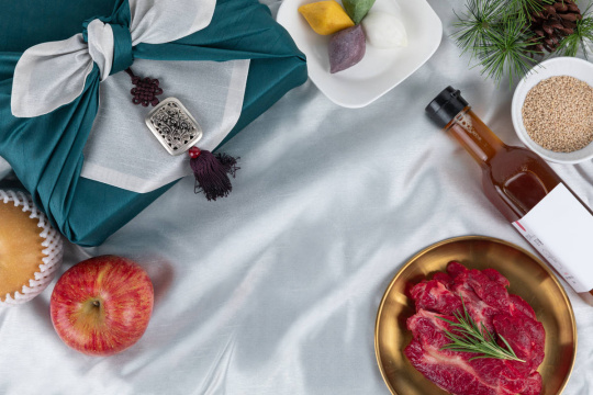 节日礼品套装 - 苹果和梨水果、与秋夕（中秋节）相关的用品、松饼、肉类以及用风吕敷包裹的礼物 顶视图图像照片 