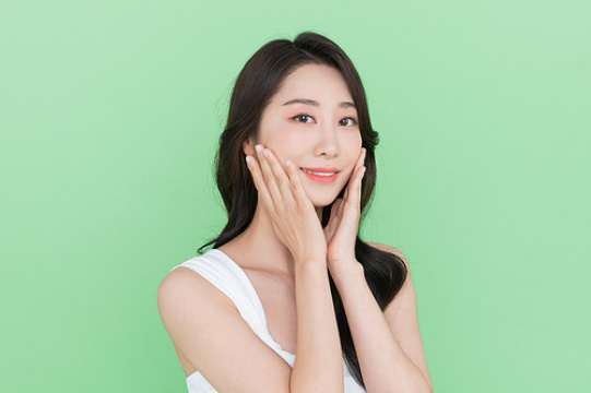 化妆 - 侧脸微笑触摸自己脸庞的女人 