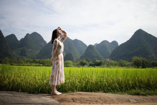 美丽的年轻女子在桂林旅行 站在稻田里