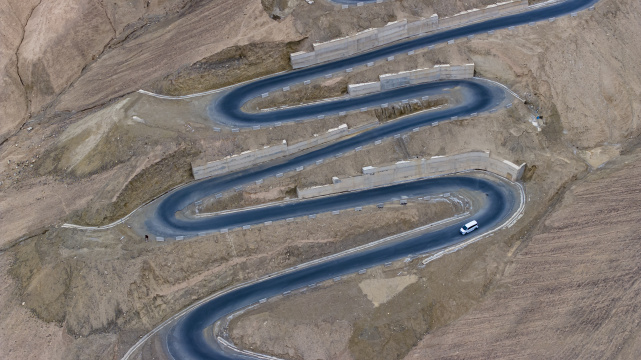 汽车行驶在蜿蜒的山路上新疆盘龙古道