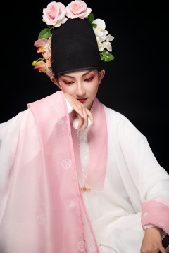 身着粤剧反串装扮手持酒杯折扇的青年女性