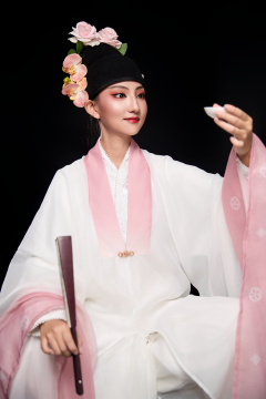 身着粤剧反串装扮手持酒杯折扇的青年女性
