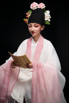 身着粤剧戏曲反串装扮手持竹简的青年女性