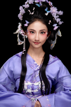 身着簪花仕女装扮坐在木桌上的东方女性