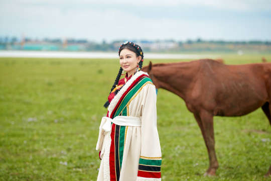 身穿藏族服饰和马匹拍照的美女
