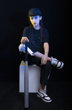 黑色背景下拿着棒球棍的冷酷女孩