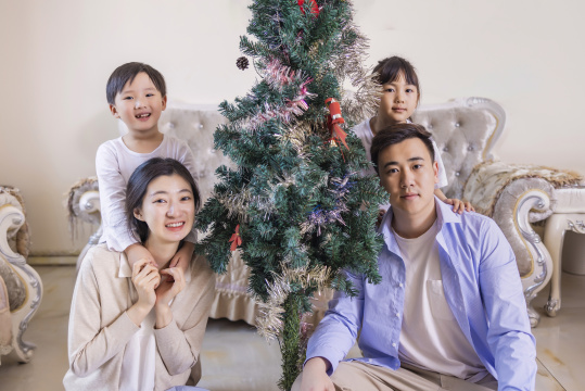 客厅里圣诞树旁的一家四口