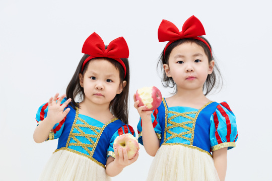 白色背景下顽皮可爱的双胞胎小女孩