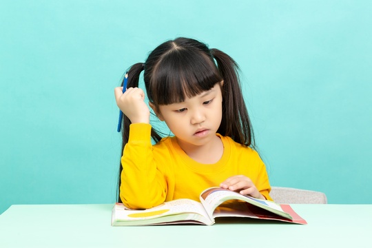 学习桌前看书学习写作业的亚洲小学生