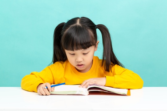 学习桌前看书学习写作业的亚洲小学生