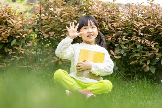 坐在草地上的亚洲小女孩