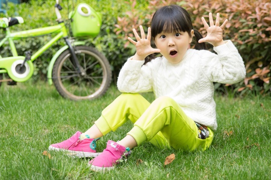 坐在草地上的亚洲小女孩