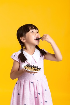 吃海苔肉松卷的亚洲小女孩棚拍半身肖像