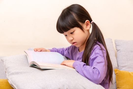 室内沙发上看书的小学生