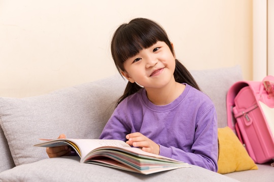 室内沙发上看书的小学生