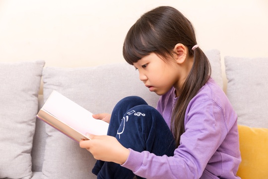 室内沙发上看书的小学生