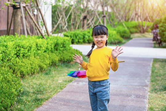 春天放学路上玩风车的小学生