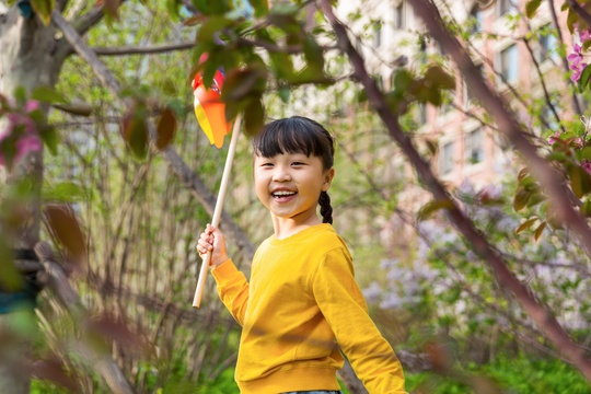 春天放学路上玩风车的小学生