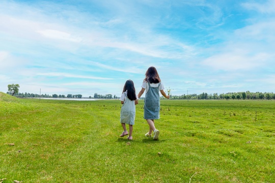 暑假旅游走在草原上的两个亚洲女孩