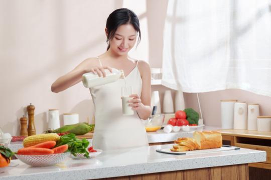 一位亚洲华裔青年女人在厨房里准备早餐